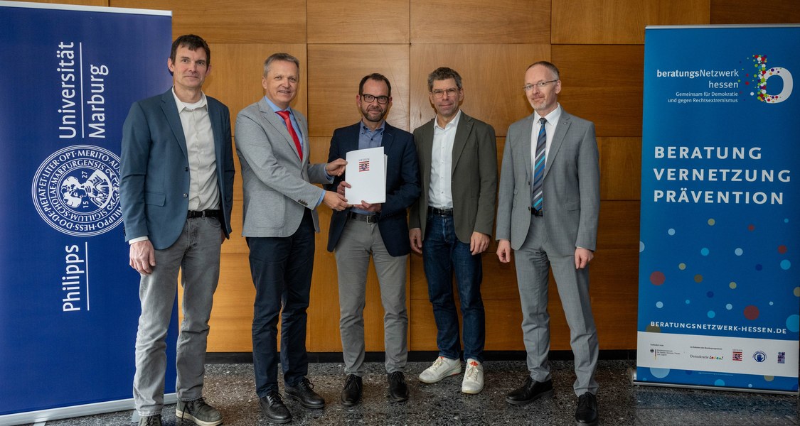 Gruppenbild der Übergabe des Förderbescheids 2025 für das Demokratiezentrum Hessen, Personen v.l.n.r. Akademischer Leiter des Demokratie Zentrums Prof. Dr. Ivo Züchner, Innenstaatssekretär Martin Rößler, Leiter des Demokratiezentrums Hessen Dr. Reiner Becker, Präsident der Philipps-Universität Marburg Prof. Thomas Nauss, Leiter HKE Dr. Klaus Bott